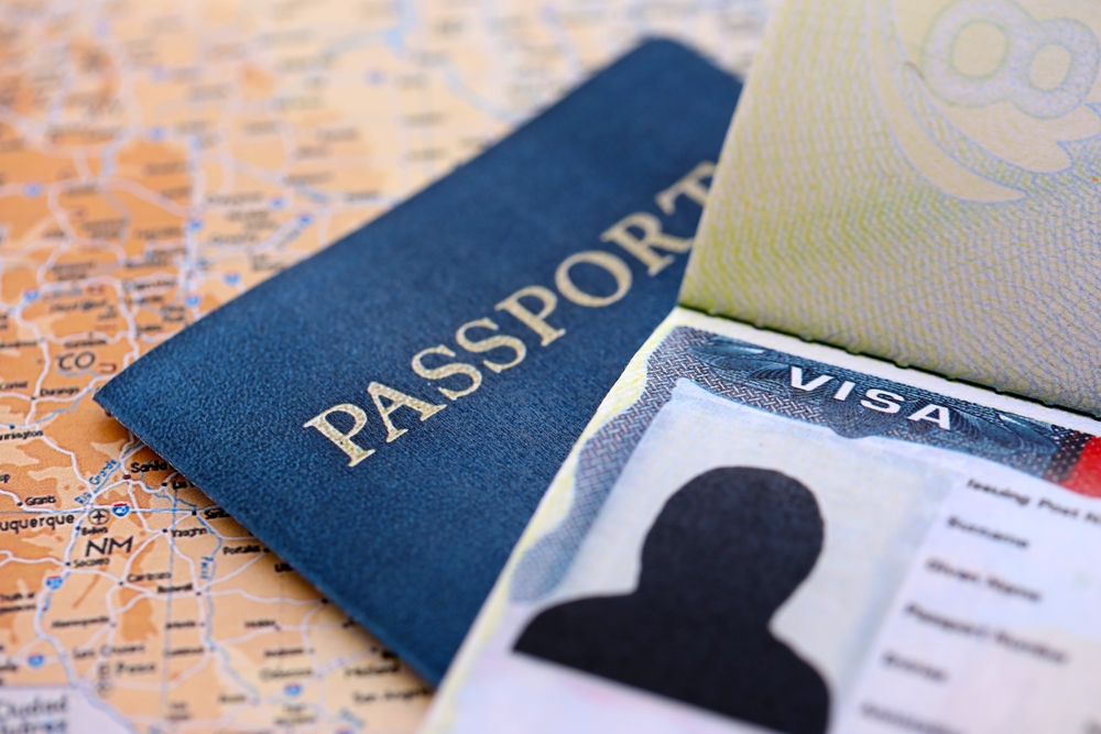 Passport and visa documents on a map, representing international travel support.